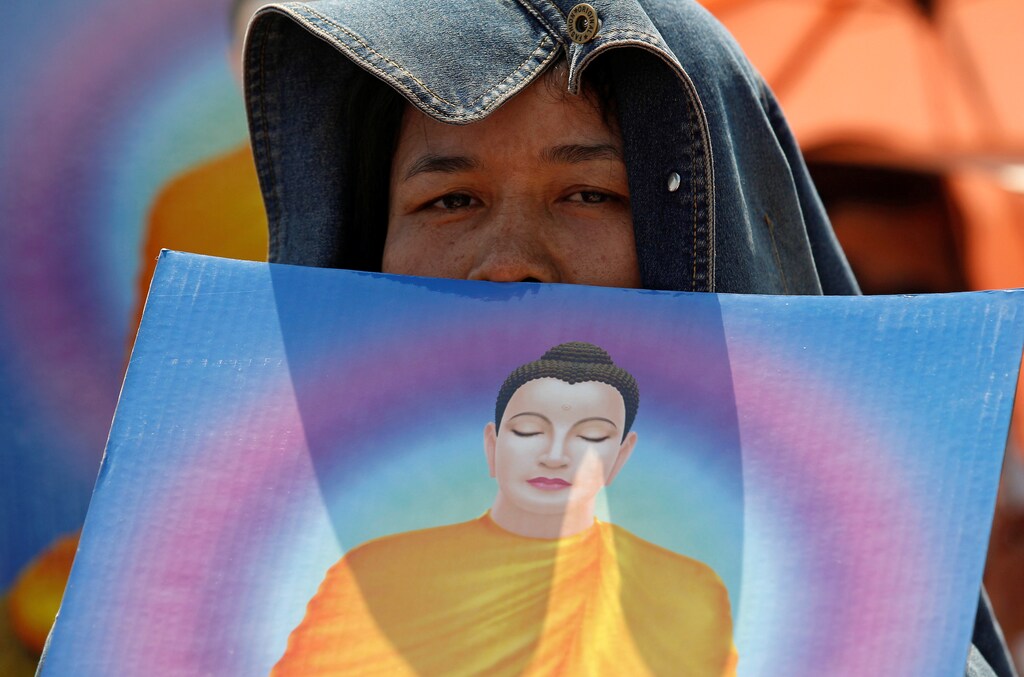 A woman prays while Thai police block access to the gate of Dhammakaya temple in Pathum Thani province, Thailand February 16, 2017. REUTERS/Chaiwat Subprasom - RTSYWFU