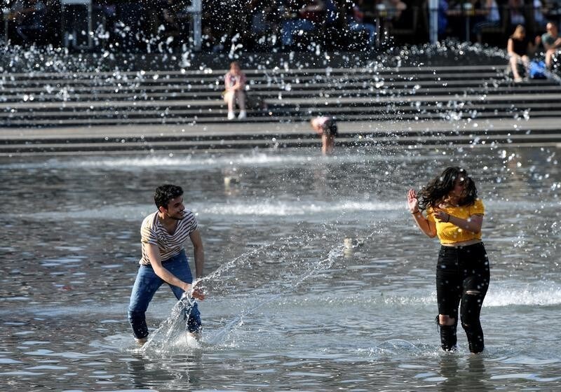Young people cool themselves off in a fountain in the Kungstradgarden Park in central Stockholm, Sweden, May 29, 2018.