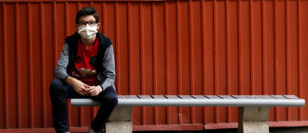 Un estudiante que regresa a la escuela en Niza, Francia, usando una máscara facial protectora.