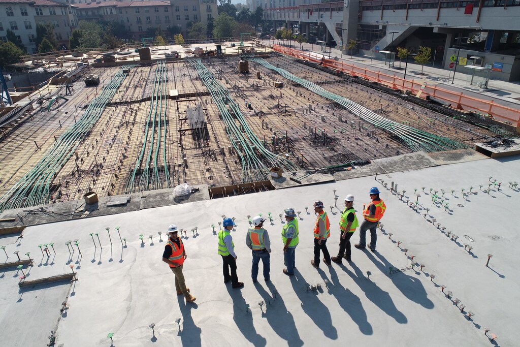 Seven construction workers standing on a building site.