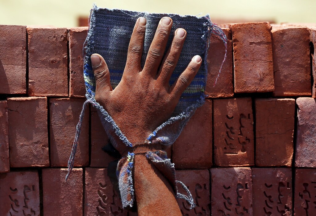 A hand of a labourer pushes bricks at a traditional brick factory in Arab Mesad district of Helwan, northeast of Cairo, May 14, 2015. Child labour is a serious problem that has a devastating impact on children's lives.