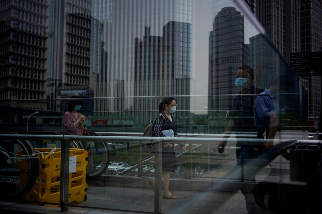 People wearing protective face masks walk past office buildings in Lujiazui financial district in Pudong, in Shanghai, following the coronavirus disease (COVID-19) outbreak, China June 4, 2020. REUTERS/Aly Song TPX IMAGES OF THE DAY - RC2E2H969UFX