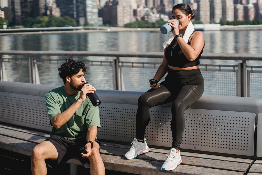 Two people drinking water after exercising.