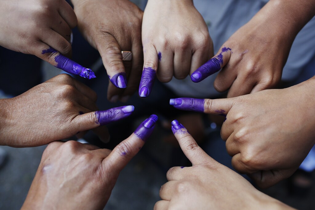 Venezuelans pose with their ink-stained fingers after voting for the successor of late President Hugo Chavez, in Caracas April 14, 2013. Venezuelans went to the polls to decide whether to honor Chavez's dying wish for a longtime loyalist to continue his hardline socialism or hand power to a young challenger vowing business-friendly changes. REUTERS/Tomas Bravo (VENEZUELA - Tags: ELECTIONS POLITICS) - GM1E94E1SHB01