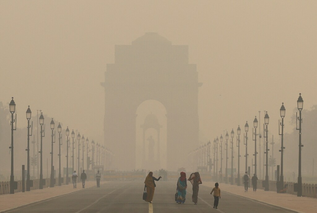 Mujeres caminando por una calle de Delhi, India, bajo un cielo envuelto en smog, 19 de noviembre de 2024. REUTERS/Anushree Fadnavis