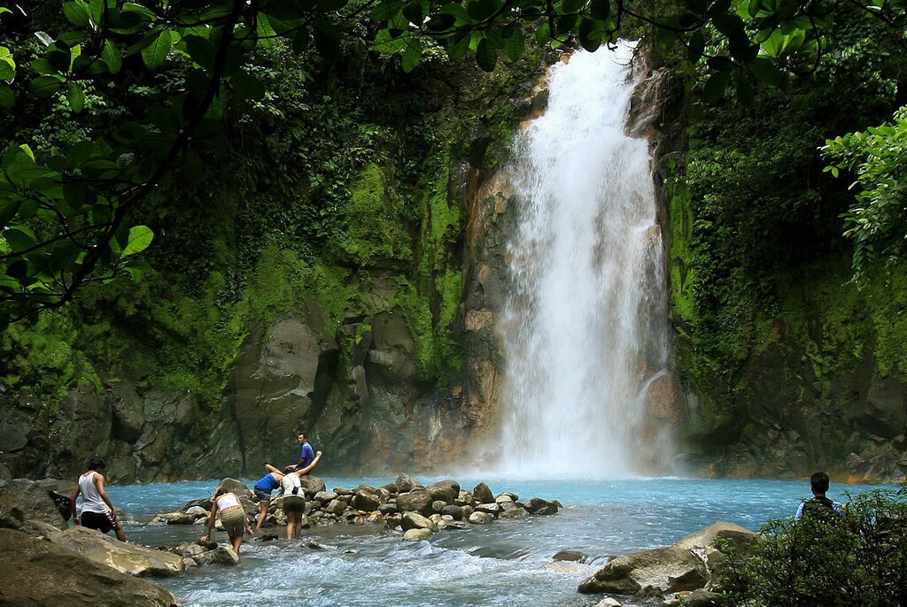 People swim in the Celeste river waterfall at Tenorio Volcano National Park in Upala March 18, 2008. The blue color of the lagoon, formed from chemical reactions of calcium carbonate and sulfur, is surrounded by amazing rainforest of 12,819 hectares of this park. The Celeste river carries its color for a distance of 36 km (22 miles). REUTERS/Juan Carlos Ulate (COSTA RICA) - GM1E43J0YXY01