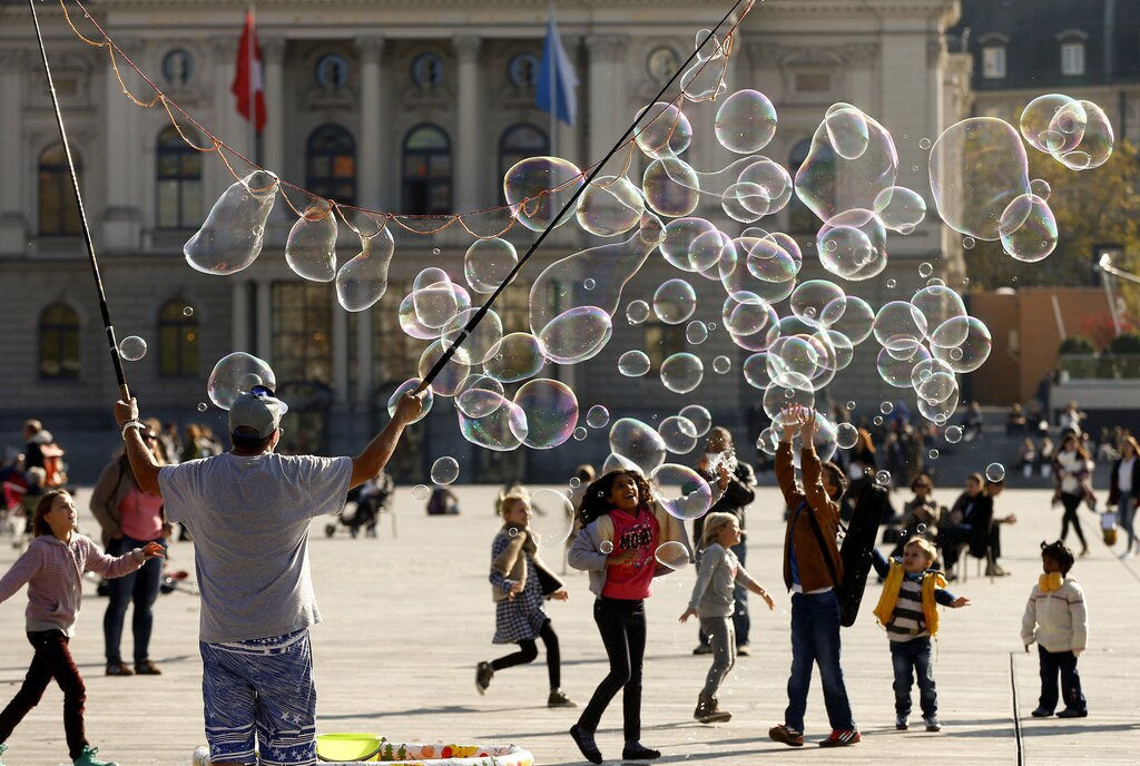 Gunnar Jauch blows big soap bubbles during sunny autumn weather at a square in front of the opera house in Zurich October 29, 2014. REUTERS/Arnd Wiegmann