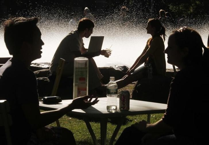 Students and visitors sit in front of a fountain at Harvard University in Cambridge, Massachusetts September 21, 2009. REUTERS/Brian Snyder (UNITED STATES)