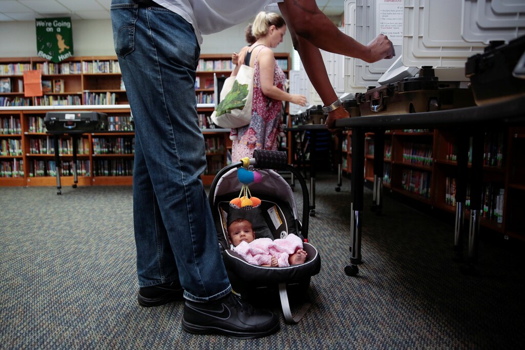 Kaia Kersaint, 10 weeks, waits patiently as her father Tino Kersaint and mother Koali Kersaint cast their votes for Georgia's 6th Congressional District special election at Livsey Elementary School in Tucker, Georgia, U.S., June 20, 2017. REUTERS/Chris Aluka Berry - RTS17WQW