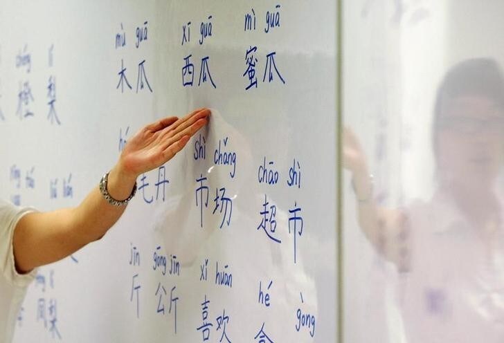 An instructor points out mandarin characters on a whiteboard at a night class for people learning mandarin as a second language in Singapore September 1, 2009. English has long united the ethnically diverse island-state but Singapore's leaders now foresee a time when Mandarin will be the country's dominant language and they are aggressively encouraging their people to become fluent in Chinese. To match feature SINGAPORE-CHINA/ REUTERS/Vivek Prakash (SINGAPORE BUSINESS SOCIETY EDUCATION)