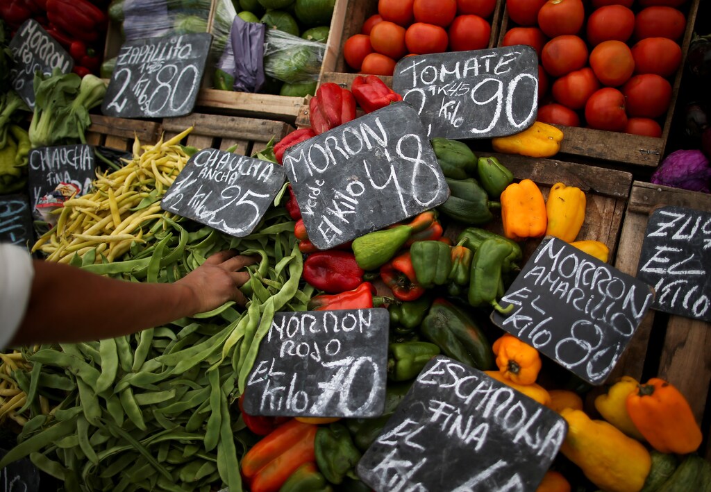 A vegetable seller grabs a handful of indian beans at a street market, in Buenos Aires, Argentina April 17, 2019.