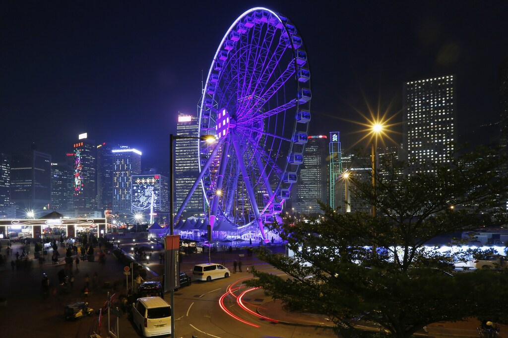 A ferris wheel and nearby office towers are lit up with decorations to celebrate the upcoming Chinese New Year of the Goat at the financial Central district, in Hong Kong February 9 , 2015. The Chinese Lunar New Year on February 19 will welcome the Year of the Sheep (also known as the Year of the Goat or Ram). REUTERS/Bobby Yip (CHINA - Tags: CITYSCAPE SOCIETY BUSINESS) - RTR4OUGN