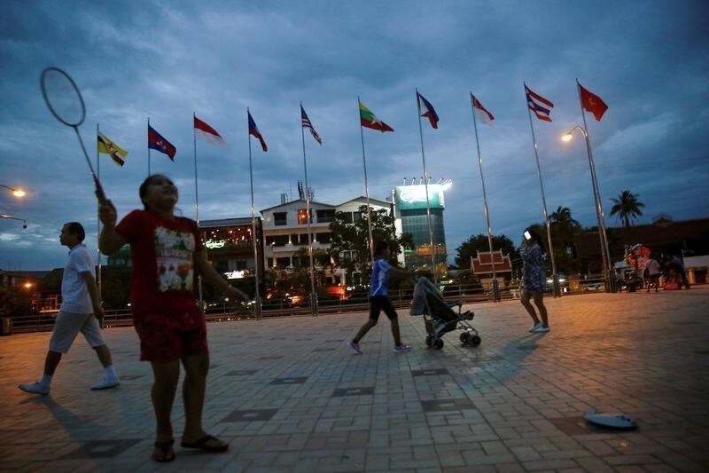 People walk past Asean countries's flags near Mekong river, ahead of the ASEAN Summit in Vientiane, Laos September 5, 2016. REUTERS/Soe Zeya Tun - D1AETZOEXIAB