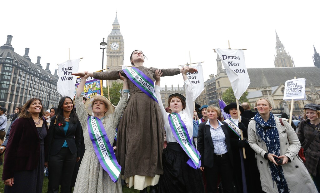 Performers dressed in period costume re-enact a march on Parliament by the suffragettes during a rally by feminist organisations to demand equality for women, in Westminster, central London, October 24, 2012. Women who earned less than men on the same pay grade when they worked for a local authority today won a battle for equal pay compensation at the UK's highest court according to local media reports. REUTERS/Andrew Winning (BRITAIN - Tags: POLITICS SOCIETY) - LM1E8AO11ZP01