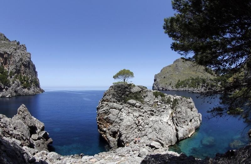 People walk on "Sa Calobra" beach, part of the cultural landscape of the Sierra de Tramuntana, on the northwestern coast of the Spanish Balearic island of Mallorca June 28, 2011. The cultural landscape of the Sierra de Tramuntana (Tramuntana mountain range) was inscribed on UNESCO's World Heritage List on Monday.