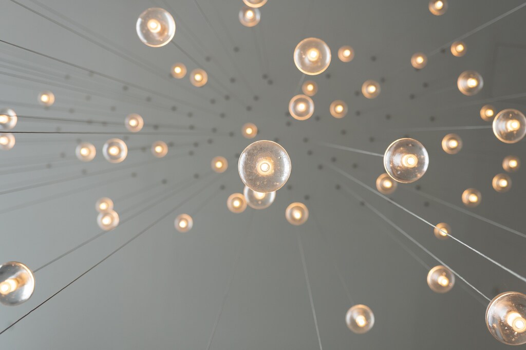 looking up at a series of lights on wires hanging from the ceiling in a story about tech innovation