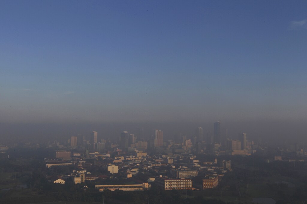 Smog from the New Year revelry covers high rise buildings in Manila January 1, 2014. REUTERS/Romeo Ranoco (PHILIPPINES - Tags: SOCIETY CITYSCAPE ENVIRONMENT) - GM1EA11127R01