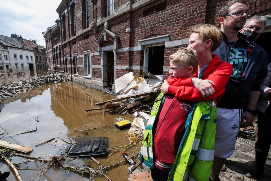 Madeline Brasseur, 37, Paul Brasseur, 42, with their son Samuel, 12, embrace each other at an area affected by floods, following heavy rainfalls, in Pepinster, Belgium, July 17, 2021. REUTERS/Yves Herman - RC2CMO9IMGTC
