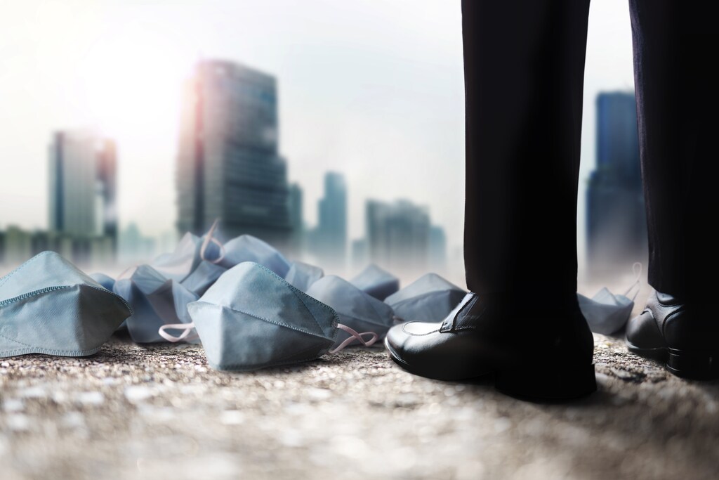 Man looks with littered face masks around his feet: Turning ambition into action can resolve global challenges in a fragmented world.