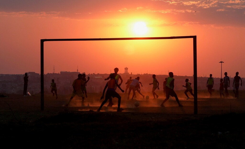 Locals play soccer on a dusty pitch in Soweto, South Africa, September 15, 2021. REUTERS/Siphiwe Sibeko TPX IMAGES OF THE DAY - RC2GQP98G1B7