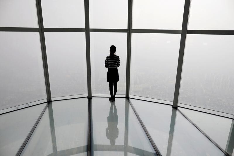 A woman looks at a view of Seoul shrouded by fine dust during a polluted day in Seoul, South Korea, March 6, 2019. REUTERS/Kim Hong-Ji TPX IMAGES OF THE DAY - RC1EC92E1360