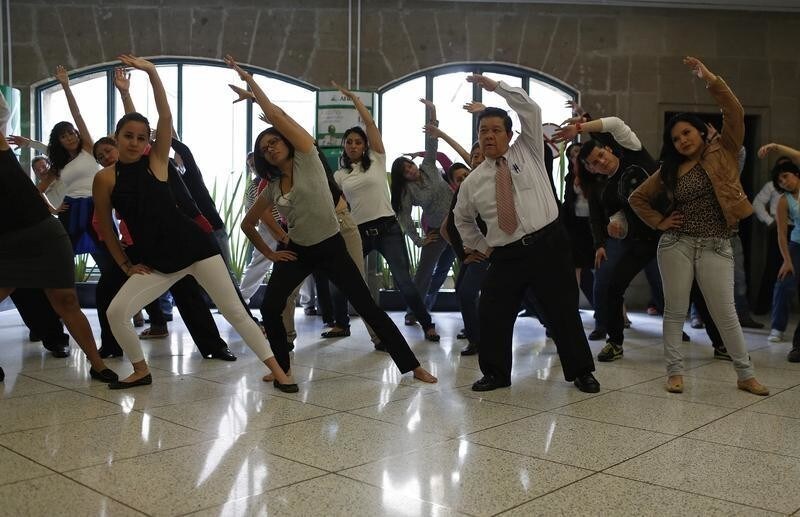 Local government employees participate in a mandatory physical activity session at their office in downtown Mexico City August 14, 2013.