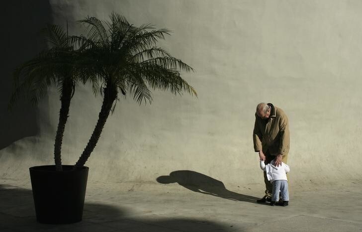 An elderly man hugs a boy in the Andalusian capital of Seville January 18, 2012. REUTERS/Marcelo del Pozo (SPAIN - Tags: SOCIETY)