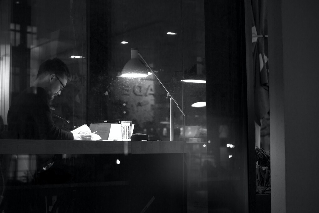 A person working at their desk in the evening.