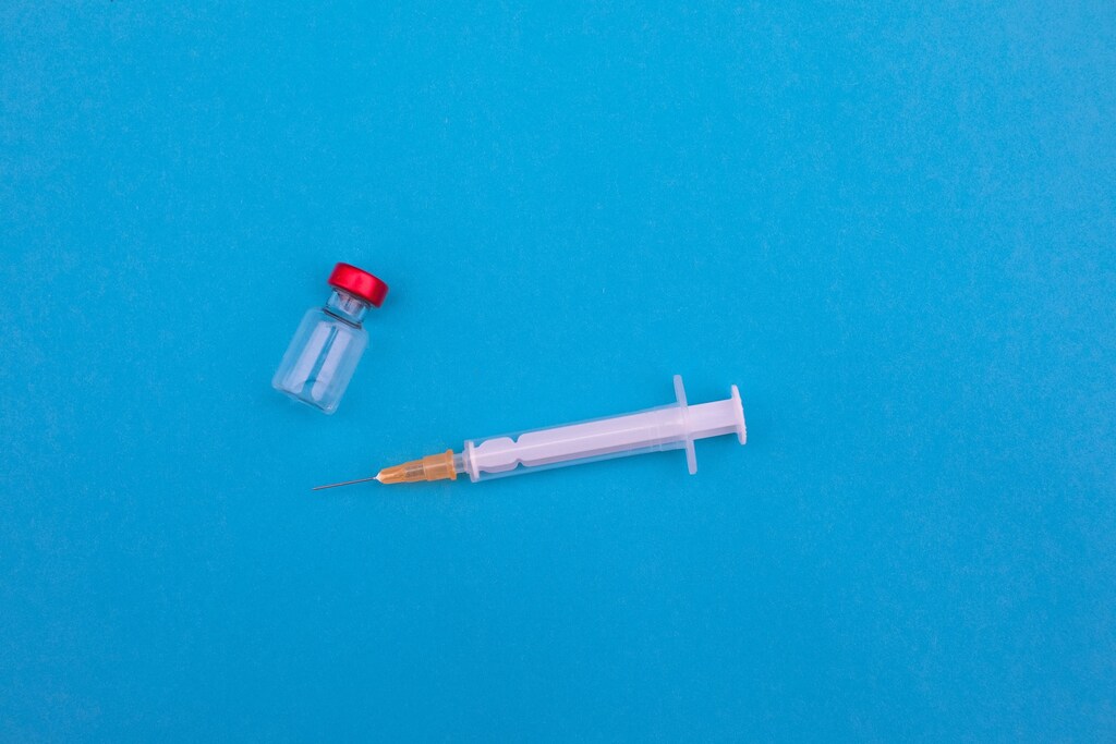 a picture of a needle and vaccine vial