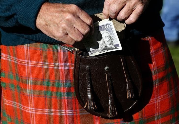 A man puts money in his sporran at the Birnam Highland Games in Scotland, August 30, 2014. Scotland will hold a referendum on independence on September 18. REUTERS/Russell Cheyne (BRITAIN - Tags: SOCIETY POLITICS)