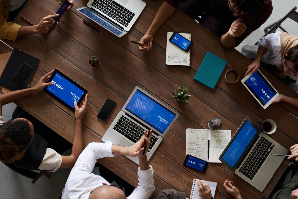 Group of coworkers having a meeting using laptops and mobile devices.