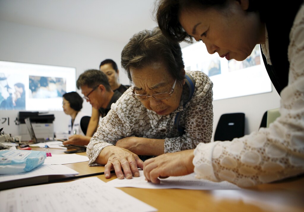 A woman who said she has family members living in North Korea gets help to prepare documents for reunion at the Red Cross building in Seoul, South Korea, September 8, 2015. Families torn apart by the Korean War six decades ago are to reunite briefly near the heavily fortified border of North and South Korea next month under a deal reached between the two sides on Tuesday, according to a statement from the South. REUTERS/Kim Hong-Ji - RTX1RKLB