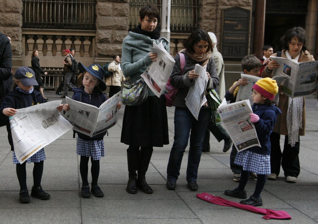 Children, mimicking the actions of their paired adult, read newspapers at Martin Place in Central Sydney September 8, 2008. The campaign,? Children see, children do, make your influence positive? was launched at the first day of the National Child Protection week. REUTERS/Daniel Munoz (AUSTRALIA) - RTX8J9Z
