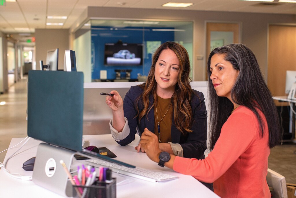 Two women sat looking at a computer. It's important to close the gender gap.