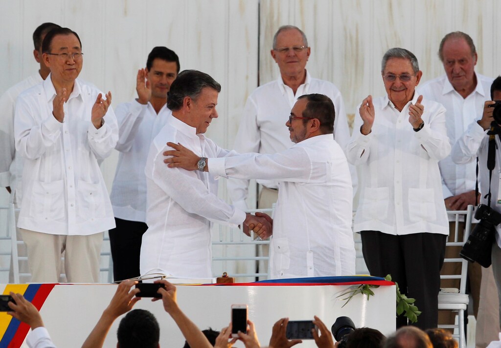 Colombian President Juan Manuel Santos (L) and Marxist rebel leader Timochenko shake hands after signing an accord ending a half-century war that killed a quarter of a million people, in Cartagena, Colombia September 26, 2016.