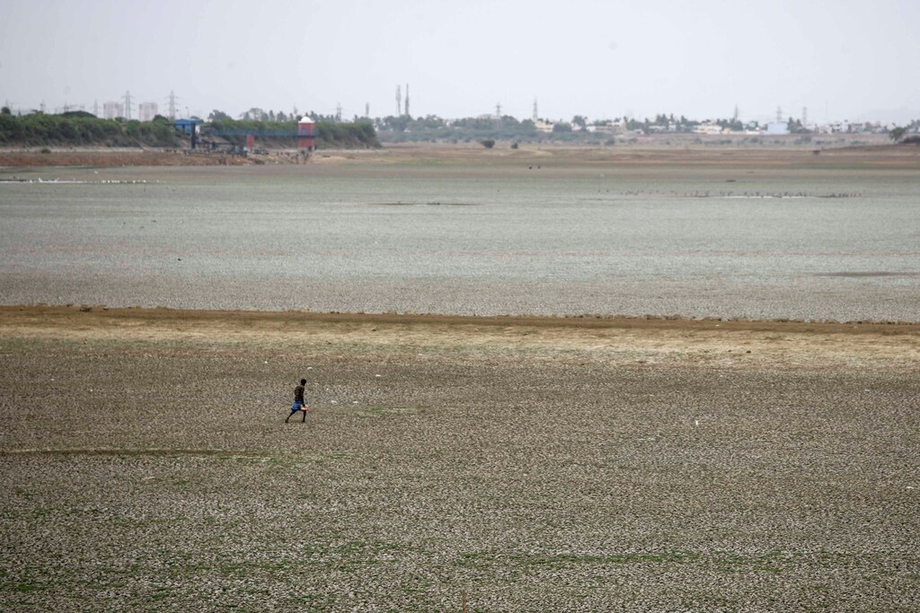 A man walks through the dried-up Puzhal reservoir, on the outskirts in Chennai, India, June 20, 2019. REUTERS/P. Ravikumar - RC1C4DEC0FC0