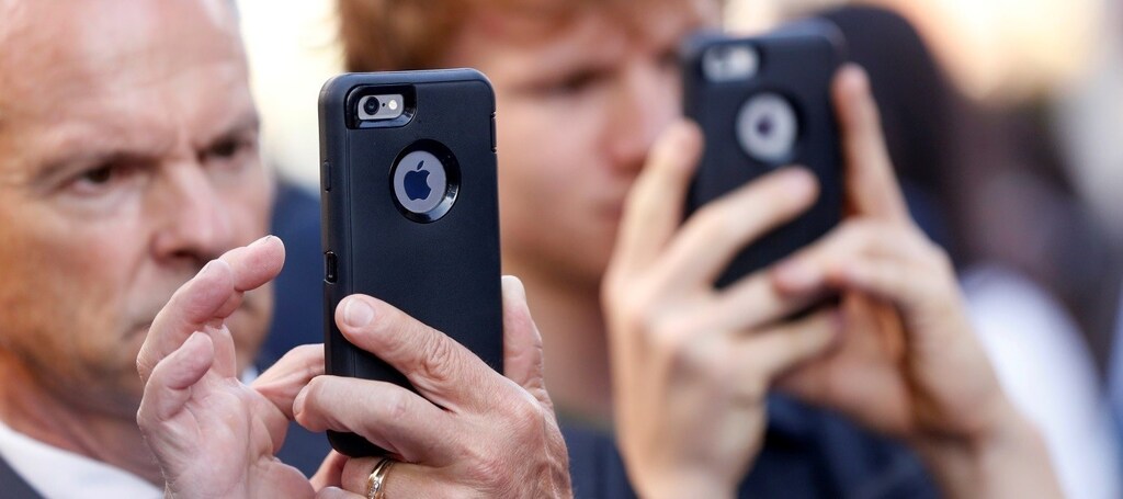 People use iPhones at the film premiere of "Nine Lives" at the TCL Chinese theatre in Hollywood
