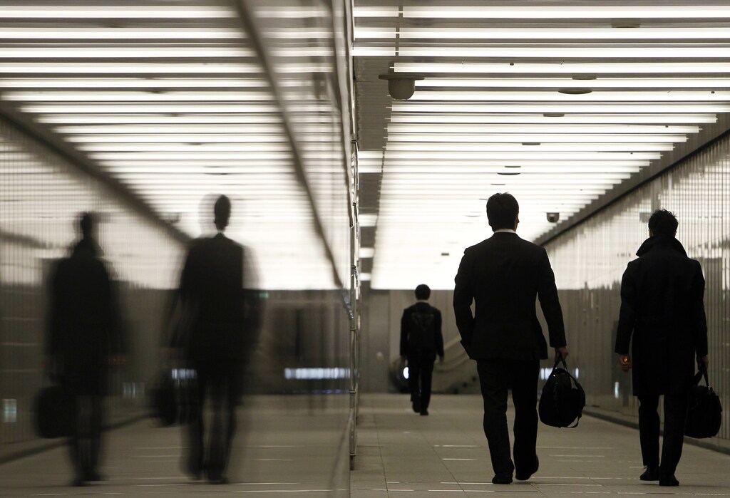 Businessmen walk through a business complex in Tokyo January 11, 2011. Japan's index of coincident economic indicators rose a preliminary 1.4 points in November from the previous month, the Cabinet Office said on Tuesday, up for the first time in three months. REUTERS/Yuriko Nakao (JAPAN - Tags: EMPLOYMENT BUSINESS POLITICS IMAGES OF THE DAY) - GM1E71B1CN001