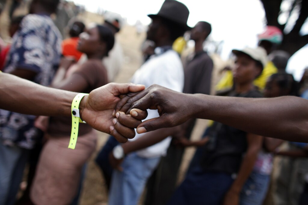Haitian volunteers hold hands in a human chain to form a queue for people to line up during a food distribution by the U.S. forces in Port-au-Prince, January 27, 2010.