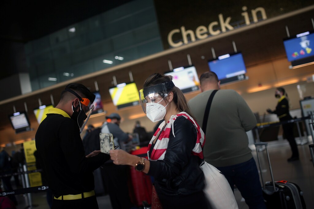 Passengers wearing face masks line up to check in at El Dorado airport, after the Colombian government gave the authorization to reactivate international flights, amidst the coronavirus disease (COVID-19) outbreak, in Bogota, Colombia September 21, 2020. REUTERS/Luisa Gonzalez - RC253J9KGO28