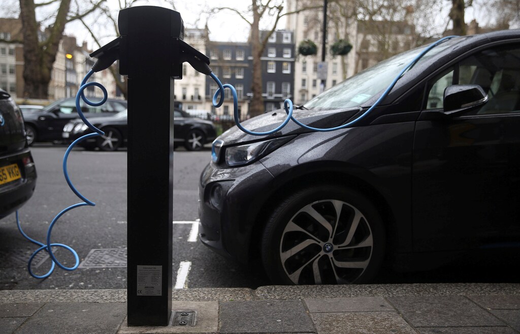 Electric cars are plugged into a charging point in London, Britain, April 7, 2016. To match Insight ELECTRIC-CAR/COMMODITIES REUTERS/Neil Hall/File Photo - RTSQT3N