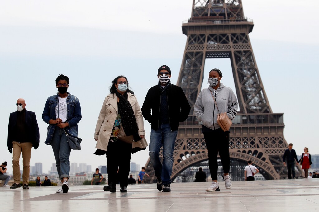 Personas con máscaras faciales caminan en la plaza de Trocadero, cerca de la Torre Eiffel, mientras Francia comenzaba a poner fin gradualmente a un bloqueo nacional debido a la enfermedad coronavirus (COVID-19) en París, Francia, el 16 de mayo de 2020.