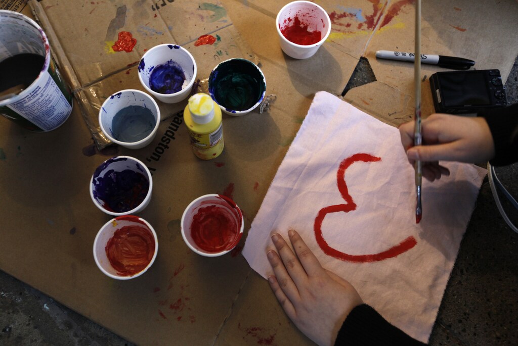A student paints a heart-shaped message outside a damaged store that was looted during riots after the NHL Stanley Cup finals in downtown Vancouver, British Columbia June 17, 2011. The riots on Wednesday began in the closing moments of Vancouver Canucks' 4-0 loss to the Boston Bruins in the deciding seventh game of the Stanley Cup NHL Championship, a series that Vancouver had been favored to win. About 150 civilians and nine police officers were hurt and at least 50 stores damaged or looted. REUTERS/Jason Lee (CANADA - Tags: CIVIL UNREST SPORT ICE HOCKEY) - GM1E76I13OH01