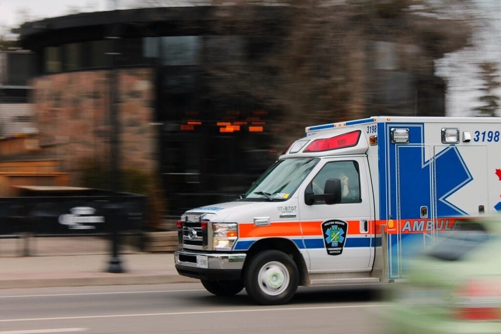 An ambulance is pictured driving down a road.