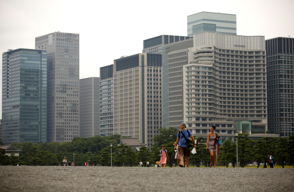 Visitors stroll at the Imperial palace as Tokyo's skyscrapers are seen in the background in Tokyo, Japan August 1, 2017. REUTERS/Issei Kato - RC14D92F10C0