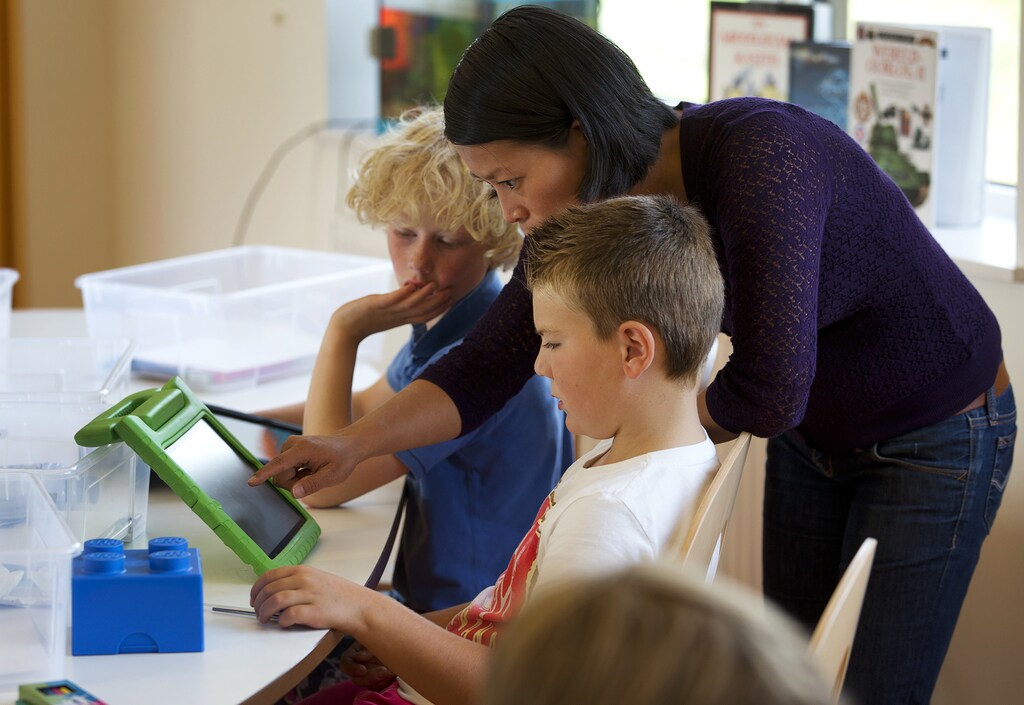 A teacher explains a math problem to students on their iPads at the Steve Jobs school in Sneek August 21, 2013. The Steve Jobs schools in the Netherlands are founded by the O4NT (Education For A New Time) organisation, which provides the children with iPads to help them learn with a more interactive experience. REUTERS/Michael Kooren (NETHERLANDS - Tags: SOCIETY EDUCATION SCIENCE TECHNOLOGY) - GM1E98L1FWQ01