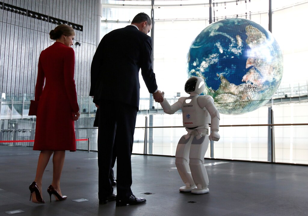 Spain's King Felipe, accompanied by Queen Letizia (L), shakes hands with Honda Motor's humanoid robot Asimo as they visit Miraikan (National Museum of Emerging Science and Innovation) in Tokyo, Japan April 5, 2017. REUTERS/Issei Kato TPX IMAGES OF THE DAY - RC16A2135340