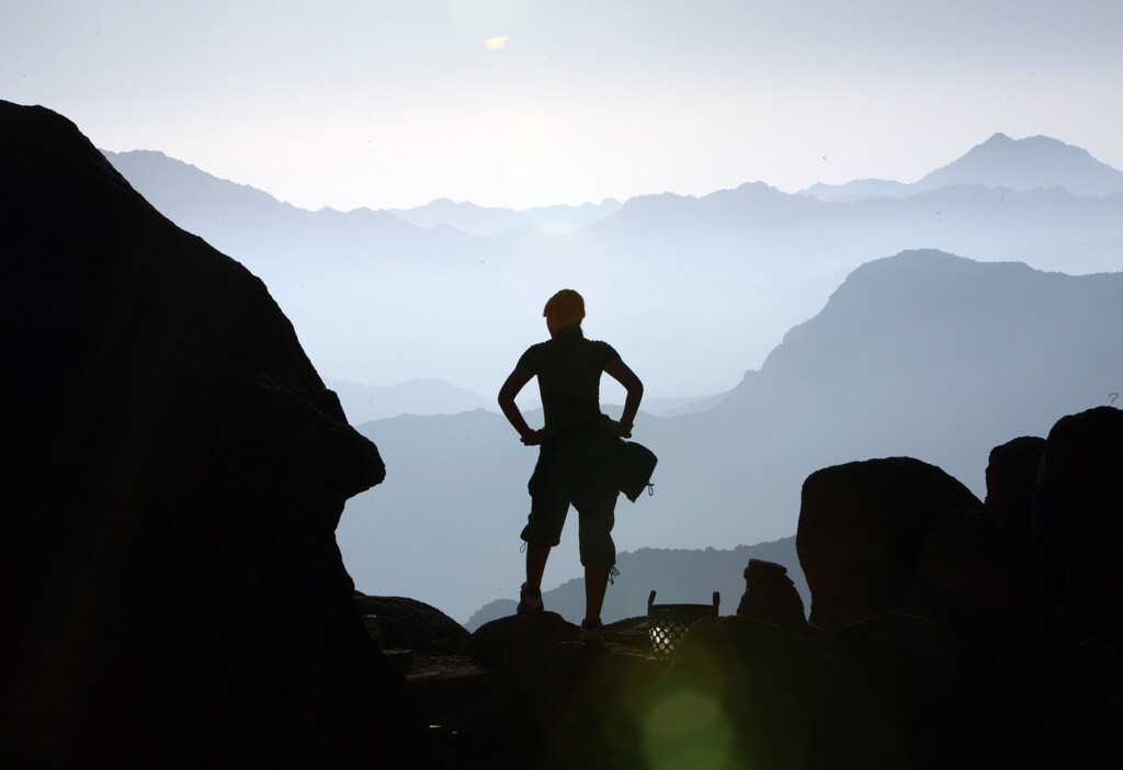 A visitor watches the sunrise at the summit of Mount Moses in the Sinai Peninsula August 10, 2009.