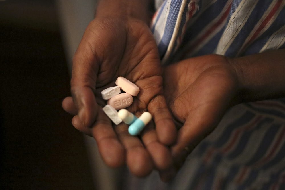 Nine-year-old Tumelo shows off antiretroviral (ARV) pills before taking his medication at Nkosi's Haven, south of Johannesburg November 28, 2014.