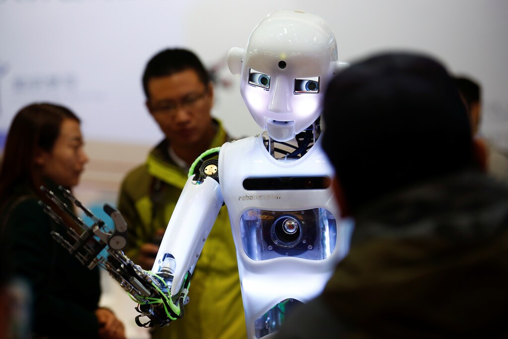 People look at a RoboThespian humanoid robot at the Tami Intelligence Technology stall at the WRC 2016 World Robot Conference in Beijing, China, October 21, 2016. REUTERS/Thomas Peter - RTX2PTOU